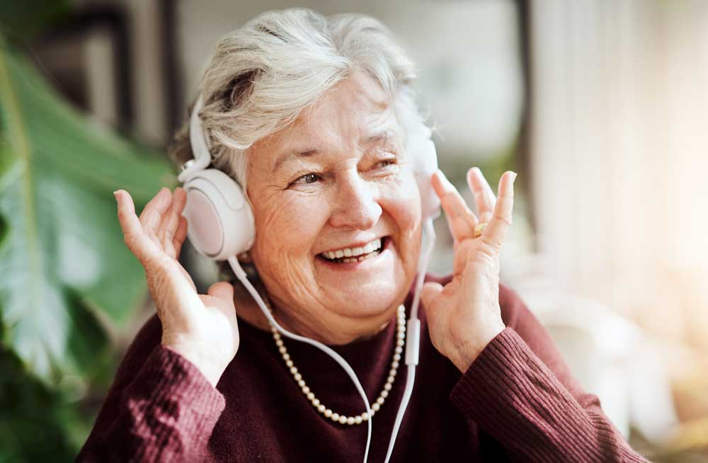 A resident listening to music via headphones at Clarendale Ann Arbor, a senior living community with care services in Ann Arbor, Michigan.