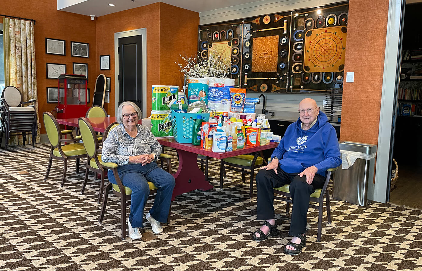 Two senior residents sit with donation drive items
