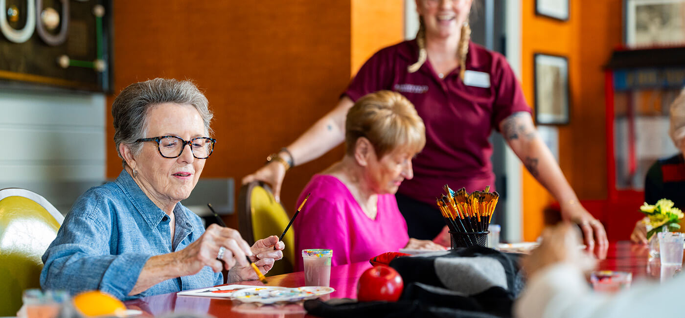 Senior woman painting during art class